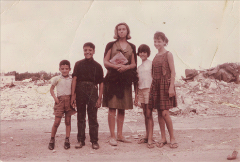 Neighborhood kids taking a photo with a tourists visiting Musrara